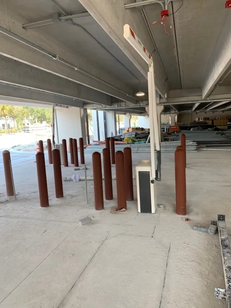 Protective bollards and lane control equipment installed at a parking garage entrance